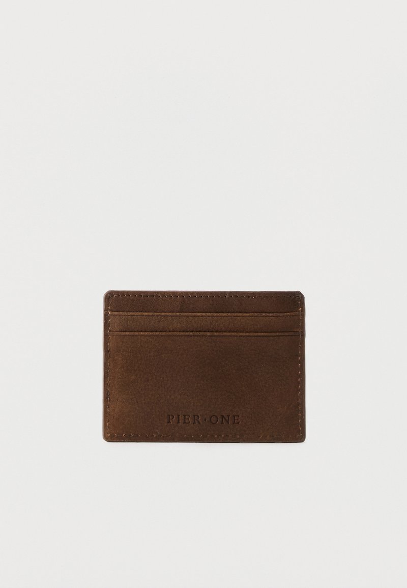 Porte-cartes en cuir marron avec trois emplacements pour cartes et "Pier One" embossé à l'avant, présenté sur fond blanc.