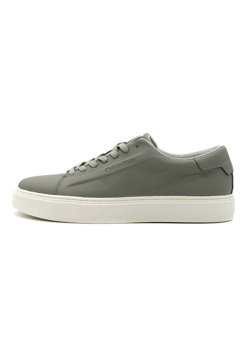 Sneakers in pelle grigia con punta rotonda, suola in gomma bianca, lacci tonali e logo del marchio sul lato. Texture liscia e design minimalista.