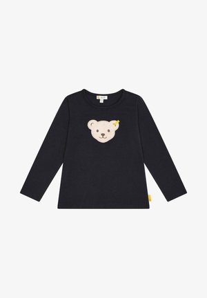 Camicia a maniche lunghe di colore blu navy in cotone, con un'applique a forma di faccia di orso crema sul petto e un piccolo etichetta gialla di lato.