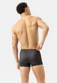 Černé boxerky s diamantovým vzorem v červené a modré barvě. Hladká tkanina, přiléhavý střih, střední pas. Zadní pohled na modela.