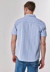 Korte mouw shirt met blauw en witte verticale strepen, een kraag en een relaxte pasvorm. Gemaakt van lichtgewicht stof, met achterste schoudernaad stiksel.