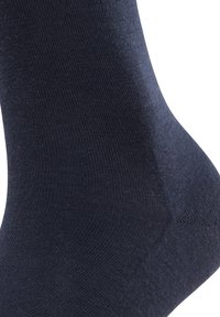 Tengerészkék zokni sima, rugalmas anyagból, varrás nélküli orrésszel és bordázott szegéllyel; testhez simuló kialakítása kényelmet és támogatást biztosít.