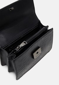 Sort tekstureret imiteret læder pung med en lynlåslomme, logo hardware og flere kortspor. Har en klaplås.