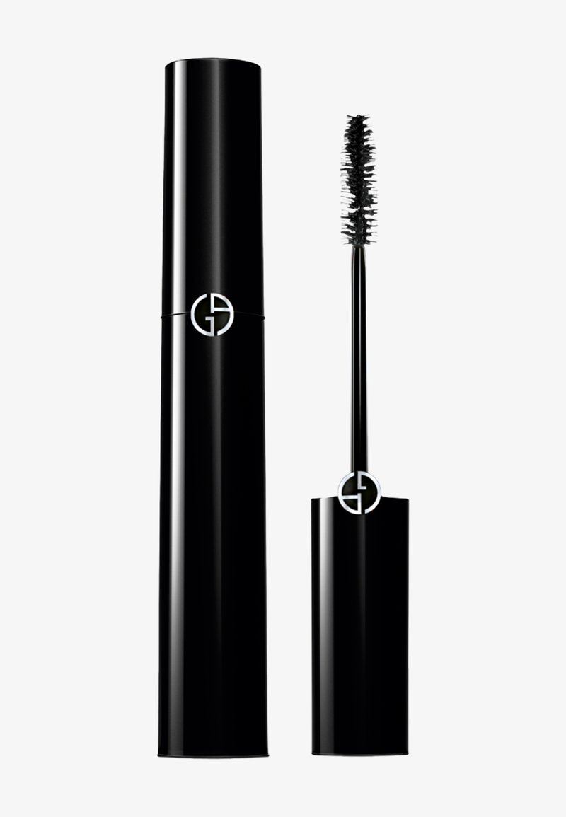 Svart mascara tube med en blank, glatt finish og en sølvfarget logo. Inkluderer en børste med korte, tette bust for påføring.