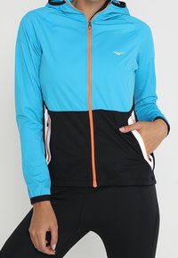 Lightweight zip-up jacket featuring a turquoise upper section and black lower section, with orange accents and white zipper details.