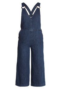 Denimoverall med mörkblå färg, vida ben, justerbara korsade axelremmar och metallhårdvarudetaljer.