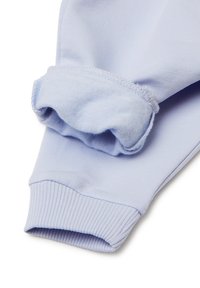 Světle modrý dlouhý rukáv s ribbonovými manžetami a měkkou, texturovanou tkaninou. Má shromážděný design na okrajích manžet.