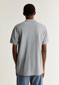 Grijze poloshirt met korte mouwen en een klassieke kraag, met een effen textuur en een ontspannen pasvorm, met een rechte zoom.