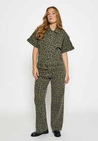 Zweiteiliges Set mit Leopardenmuster in Olivgrün, bestehend aus einem kurzärmligen Hemd mit Kragen und weit geschnittenen Hosen mit lockerem Sitz.