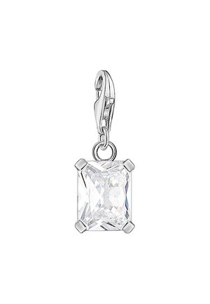 Srebrny karabińczyk trzymający prostokątną, przejrzystą, fasetowaną zawieszkę z kamieniem szlachetnym na czterech łapkach na białym tle.