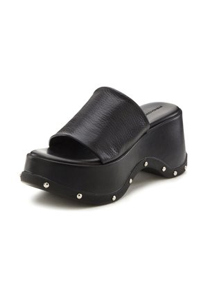 Black platform slide sandals with a textured leather strap, curved sole, and metallic studs along the outer edge. Smooth finish on footbed.