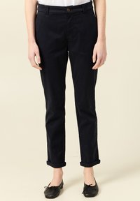 Marinblå bomullsbyxor med slim fit, med framknappstängning och uppvikta fållar. Slät textur och minimal dekoration.