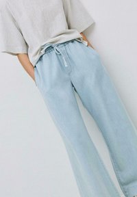 Helle blaue Denim-Jogginghosen mit einem elastischen Bund und verstellbarem Kordelzug, mit Seitentaschen und lässiger Passform.