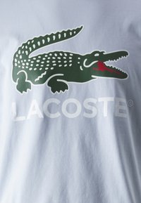 Lacoste Nyomott mintás póló - phoenix blue