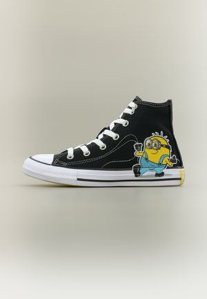 Zapatilla negra de caña alta con cordones y suela blanca, con un personaje amarillo Minion vestido con un overol azul en el lateral.