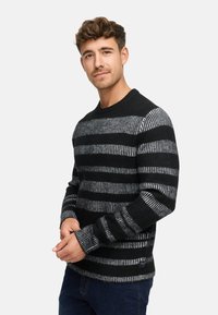Sort og grå stribet sweater, strikket materiale, rund halsudskæring, lange ærmer med ribbede manchetter. Har skiftende ensfarvede og mønstrede striber.