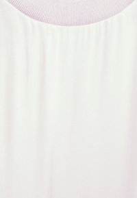 Tecido suave de cor rosa claro, com uma textura lisa; apresenta um decote canelado; design minimalista sem padrões ou adornos.