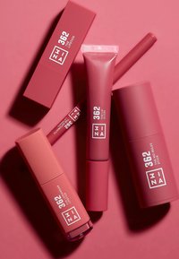 Fire rosa leppeprodukter med matte og glansfulle overflater, sylinderformede og rektangulære former, med hvit merking på hver emballasje.