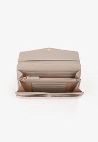 Portafoglio in pelle grigio chiaro con un design strutturato, dotato di più scomparti per carte, un vano con cerniera e un accento con logo in tono oro.