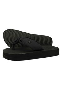 Black flip-flops with textured rubber soles and fabric straps. The straps feature a knotted design and an accent logo.