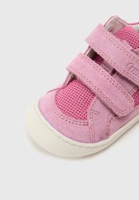 Ροζ παιδικό παπούτσι που συνδυάζει σουέτ και δίχτυ, με διπλές λουρίδες βέλκρο και λευκή λαστιχένια σόλα.
