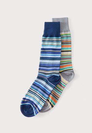 Paire de chaussettes mi-mollet à rayures horizontales multicolores ; une chaussette a un bord bleu marine, l’autre un bord gris clair.