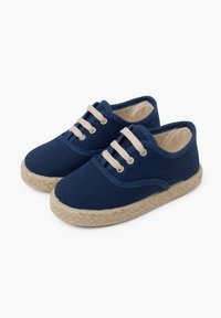 Marineblauwe canvas schoenen met beige veters, ronde neus en geweven jute zool. Heeft gestikte details langs de bovenrand.