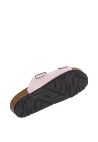Chaussure en suede rose avec des doubles brides, une semelle intermédiaire en liège et une semelle extérieure en caoutchouc noir texturé, présentant un motif de relief pour une meilleure adhérence.