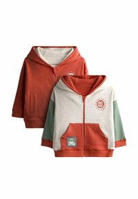 Twee hoodies. De ene heeft oranje en beige kleuren met een logo; de andere combineert beige, oranje en groen met een patchdetail.