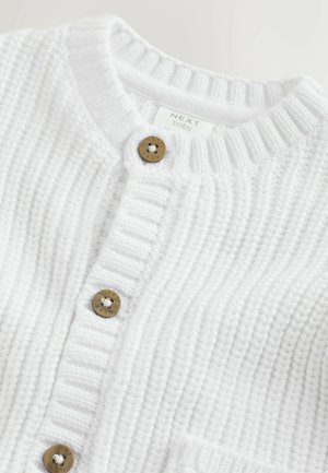 Biały dziany kardigan wykonany z tkaniny o fakturze, z okrągłym dekoltem, prążkowanymi krawędziami i trzema brązowymi guzikami z przodu.
