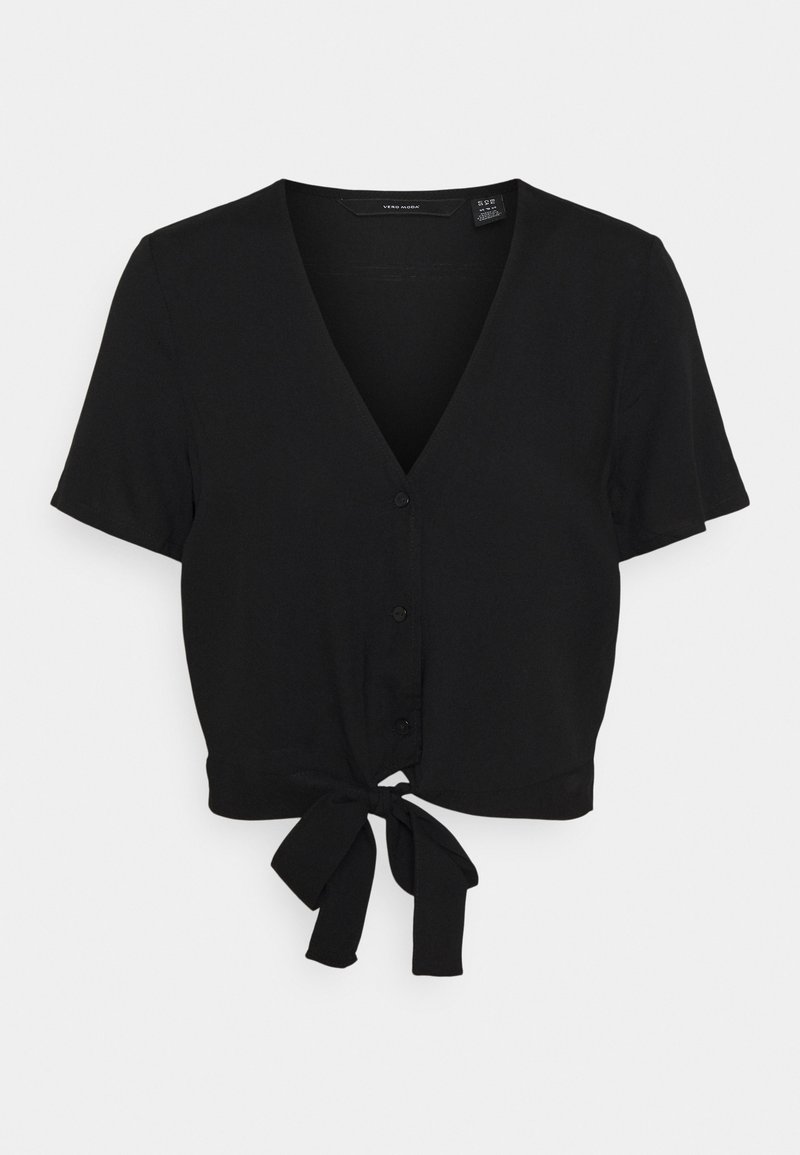 Blouse noire courte à manches courtes avec col en V, boutons sur le devant et nœud noué à l'ourlet, présentée sur un fond clair uni.