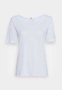 Vaaleansininen lyhythihainen t-paita, jossa on pyöreä kaula-aukko. Sileä kangas ja rento istuvuus. Pieni brändätty yksityiskohta hihassa.