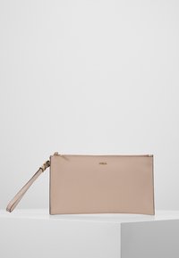 Béžová kožená psaníčko na zápěstí se zlatým zipem a malým zlatým logem na přední straně, vystavené na bílém geometrickém podstavci na jednoduchém pozadí.