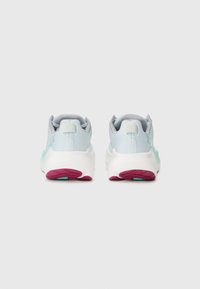 Des chaussures de sport bleu clair avec des semelles blanches et violettes, présentant une tige texturée, un collier rembourré et un design bicolore sur les côtés.