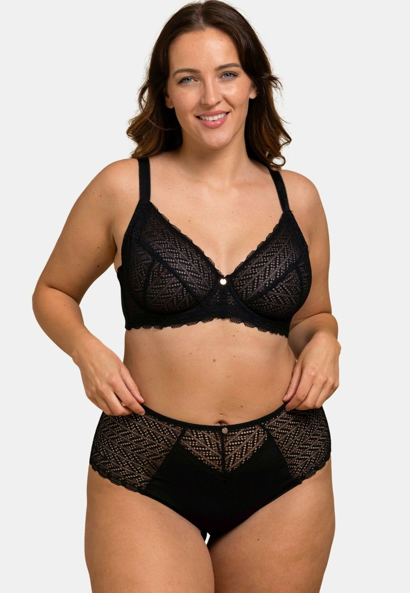 Un soutien-gorge en dentelle noire et des culottes taille haute présentent des motifs géométriques, des bords festonnés et un petit bouton décoratif sur la ceinture.