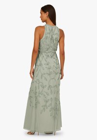 Długa, miętowozielona suknia wieczorowa z misternym zdobieniem z koralików i kwiatowymi wzorami, z bezrękawnikowym krojem i zwiewną sylwetką.