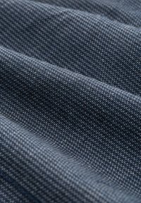 D denimstoff in Dunkelblau mit feiner, gewebter Textur, die subtile Farbvariationen zeigt und eine sanfte Drapierung über die Oberfläche aufweist.
