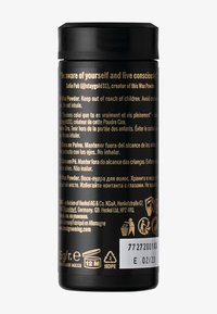 Svart cylindrisk behållare med matt yta. Har präglad guldfärgad text och varningsetiketter på flera språk. Kapacitet på 75 g, återvinningsbara material anges.