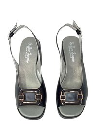 Décolleté nere con tacco, caratterizzate da un'apertura sulla punta, con un accento in fibbia dorata, una texture in pelle liscia e solette grigie.