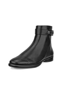 Botte de cheville en cuir noir avec un bout arrondi, texture lisse, et une sangle ajustable autour de la cheville ornée d'une boucle métallique.