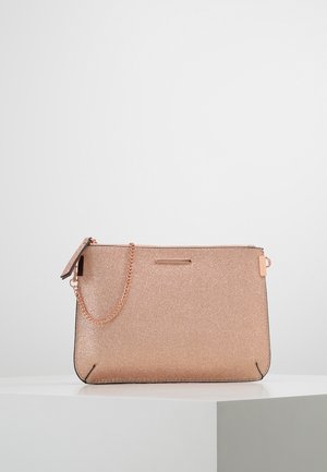 Rechteckige Clutch mit roségoldenem Glitzer, mit roségoldener Kette und Reißverschluss, auf weißem Sockel vor schlichter Kulisse präsentiert.