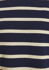 Námořnická modrá a béžová pruhovaná tkanina s střídajícími se širokými horizontálními pruhy. Měkčí textura, lehký materiál, vhodný pro každodenní nošení.