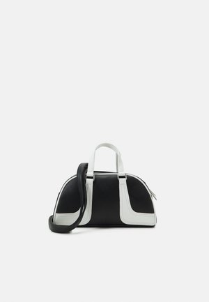 Schwarz-weiße kleine Handtasche mit geschwungener Form, zwei weißen oberen Griffen und einem abnehmbaren schwarzen Schulterriemen.