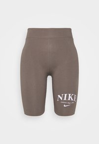 Bruna, högmidjade cykelshorts i stretchigt material. Har "NIKE"-logotyp och texten "Athletic dept. 1972" i vitt på vänster ben.