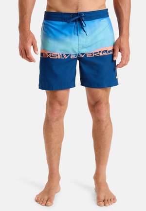 Herrarnas badshorts i blå gradient med orange logotyp. Har dragsko i midjan, lätt material och två sidofickor.