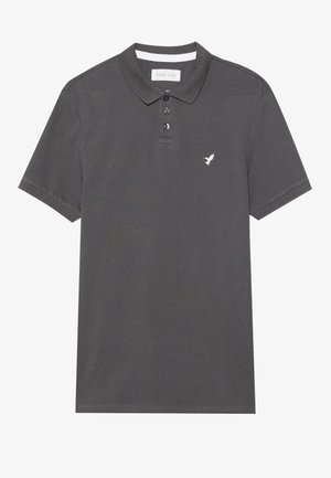 Siva polo majica od pamuka, s tri dugmeta kopčanja, kratkim rukavima i malim bijelim logom ptice na lijevoj strani prsnog dijela.
