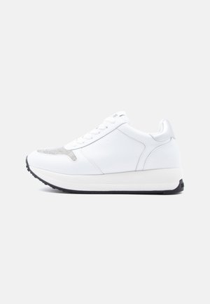 Weißer Sneaker mit glattem Lederobermaterial, strukturierten silbernen Akzenten an der Spitze und einer weißen Plateausohle mit schwarzer Gummilaufsohle.