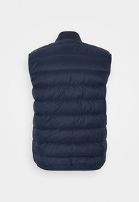 Chaleco acolchado azul marino con cuello alto, que presenta secciones acolchadas horizontales y una textura suave. Sin herrajes ni acentos visibles.