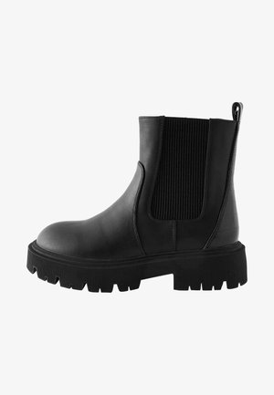 Bottines noires en cuir avec panneaux élastiques sur les côtés, dos texturé, semelle en caoutchouc épaisse et languette pour un enfilage facile.