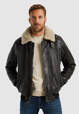 Schwarze Lederjacke mit einem hellbraunen Schafwollkragen, Reißverschluss vorne und zwei Fronttaschen, mit strukturierten Schultern und kontrastierenden Steppnähten.